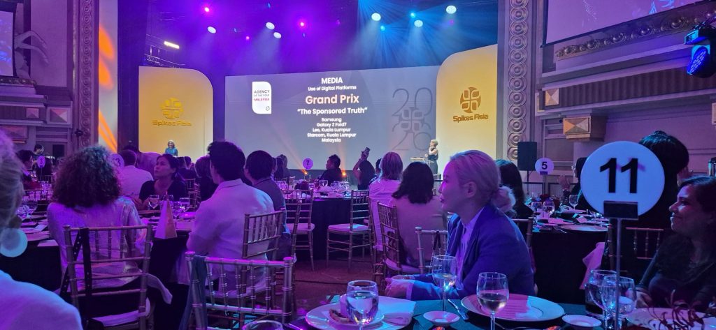 A group of award winners standing on stage at Spikes Asia 2026 under a screen announcing the Grand Prix for "The Sponsored Truth" by Samsung and Leo Burnett Kuala Lumpur